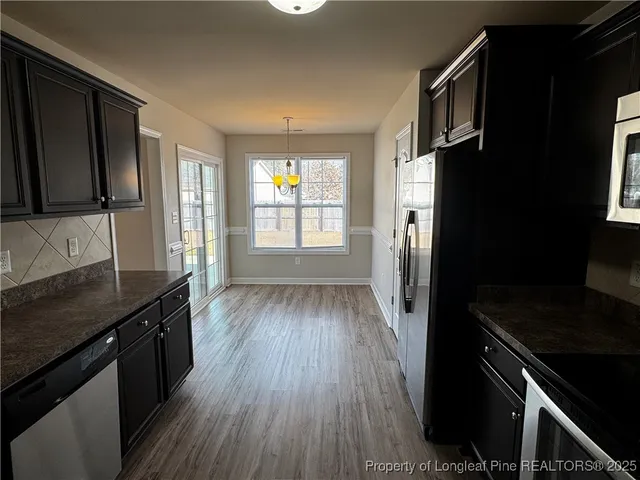 a kitchen with granite countertop a stove a sink and a refrigerator