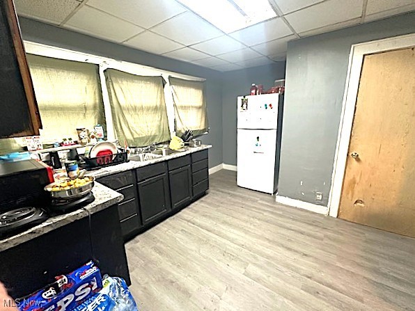1209 Rice Avenue Lima, OH 45805 - Photo 2 of 14 Kitchen featuring a drop ceiling, light wood-type flooring, light countertops, freestanding refrigerator, and dark cabinetry