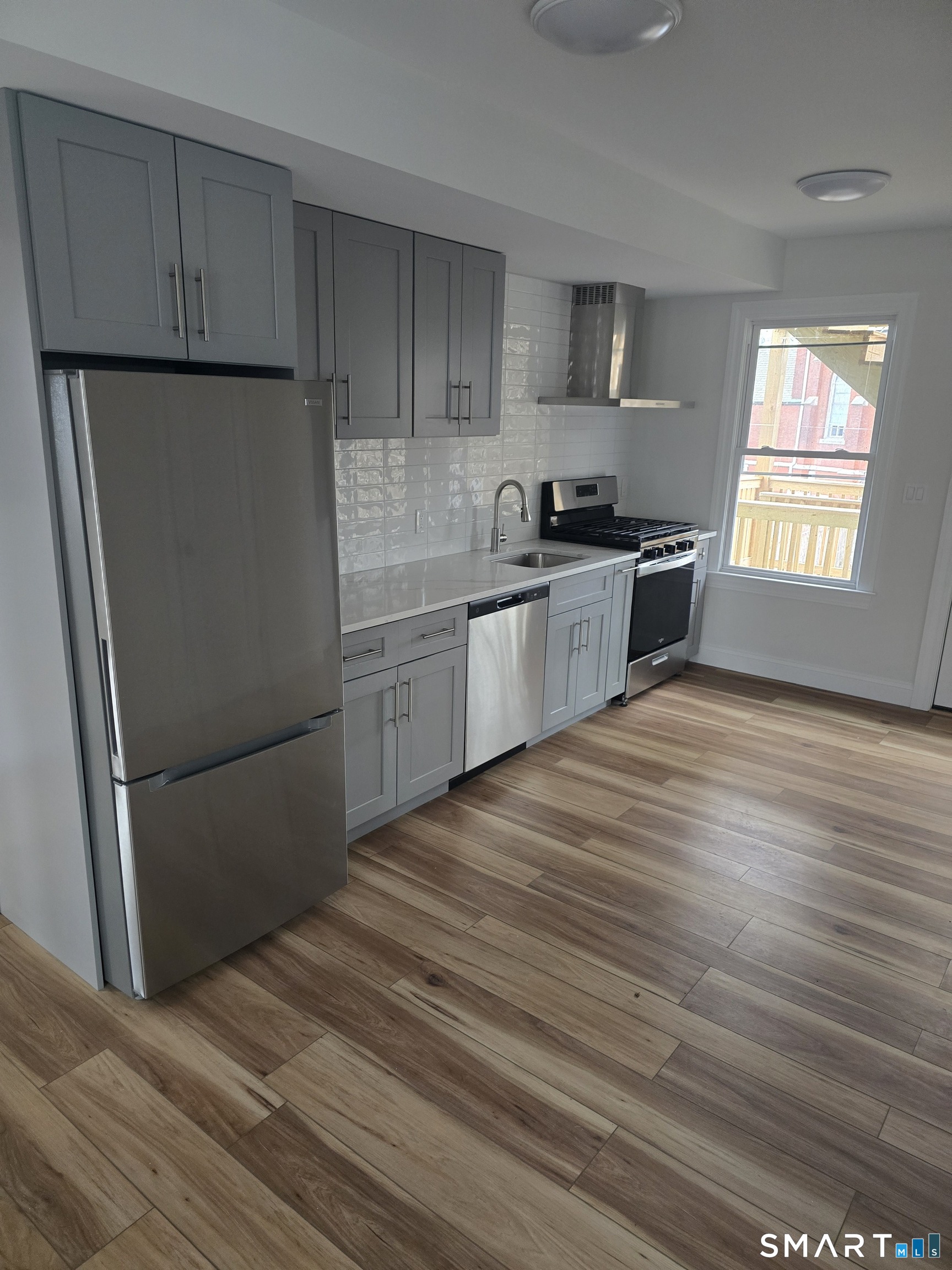 530 Jane Street, Unit 3 Bridgeport, CT 06608 - Photo 2 of 9 a kitchen with granite countertop a refrigerator sink and cabinets