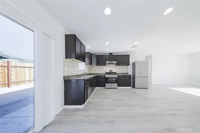 a view of a kitchen with a sink and a refrigerator