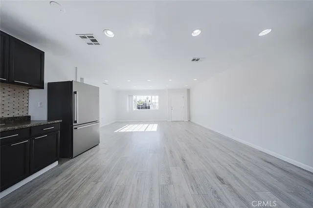 a kitchen with stainless steel appliances granite countertop a stove a sink and a refrigerator