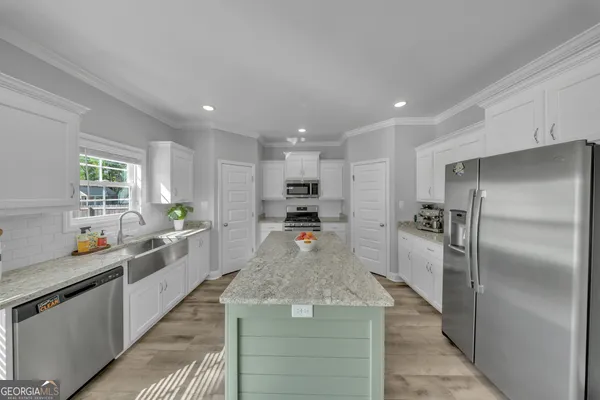 a large kitchen with stainless steel appliances granite countertop a sink stove and refrigerator