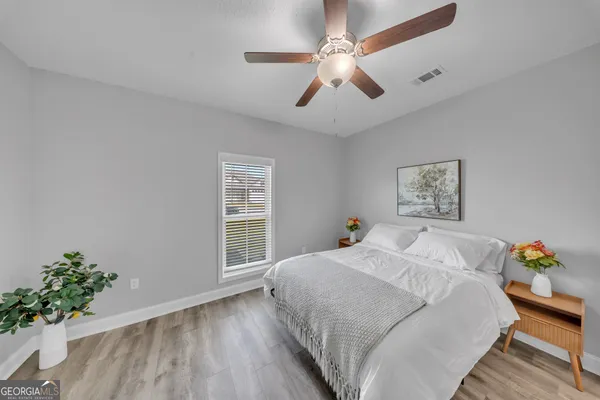 a bedroom with a large bed chandelier and a window
