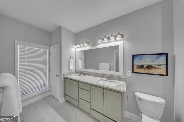 a spacious bathroom with a toilet sink and mirror