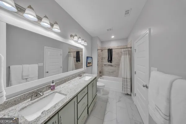 a bathroom with a double vanity sink mirror double and shower