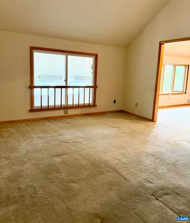 a room with stainless steel appliances kitchen island a table chairs in it and a window