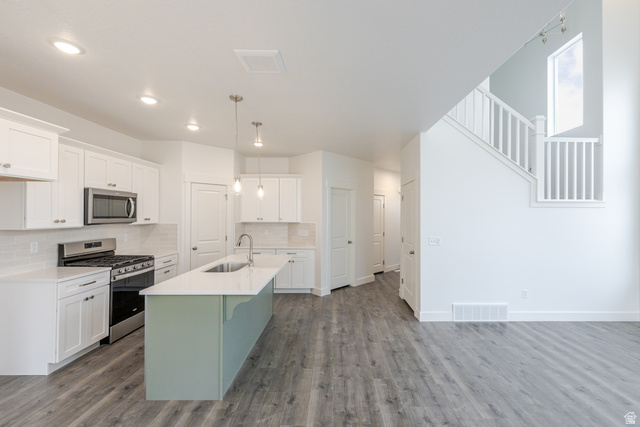4741 Olive Avenue, Unit 406 Mapleton, UT 84664 - Photo 9 of 20 Kitchen featuring stainless steel appliances, an island with sink, dual tone cabinets, pendant lighting, and tasteful backsplash