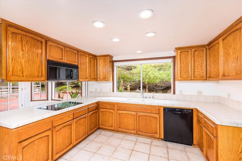 1766 Rabbit Hill Fallbrook, CA 92028 - Photo 23 of 75 a kitchen with a sink window and cabinets