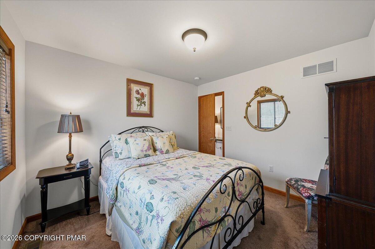 3176 Bluebird Drive Bushkill, PA 18324 - Photo 26 of 37 a bedroom with a bed and a lamp on table