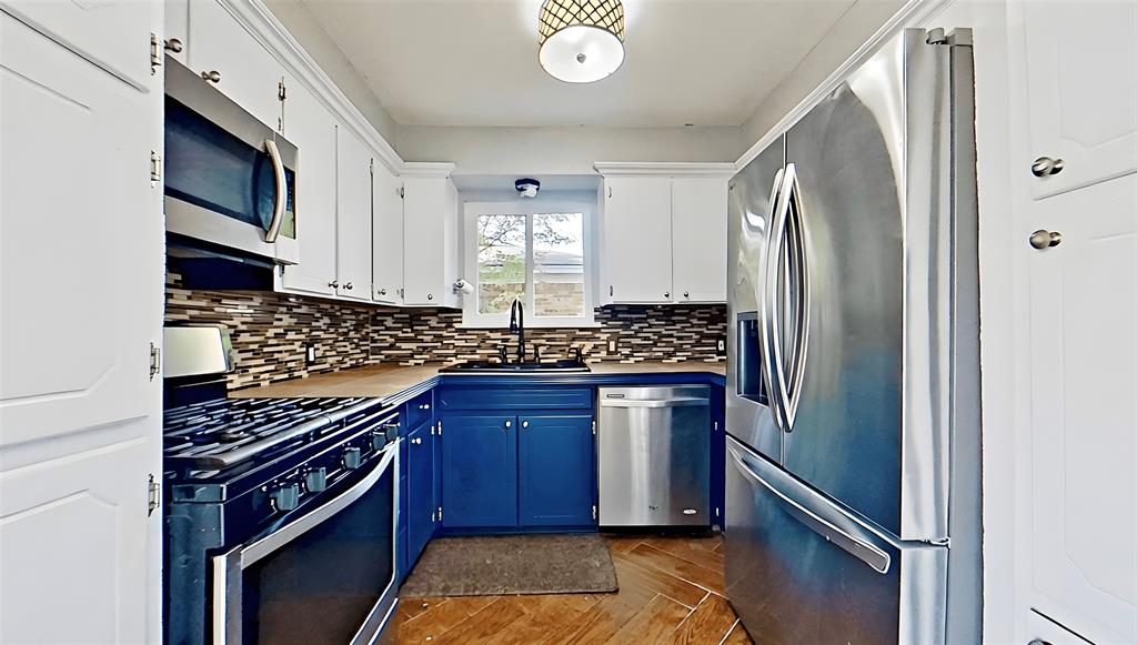 5016 St Lawrence Road Fort Worth, TX 76103 - Photo 11 of 22 a kitchen with stainless steel appliances granite countertop a refrigerator a sink and wooden cabinets