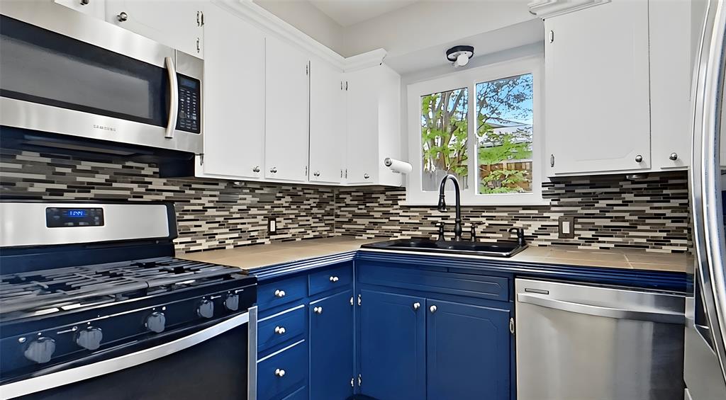 5016 St Lawrence Road Fort Worth, TX 76103 - Photo 12 of 22 a kitchen with stainless steel appliances a stove a sink and a microwave