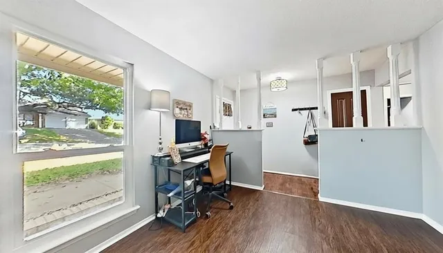 a view of a workspace with furniture and a window