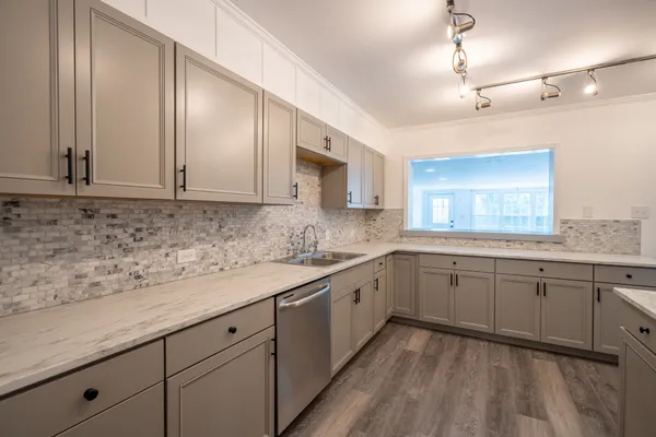 a kitchen with granite countertop cabinets stainless steel appliances a sink and a window