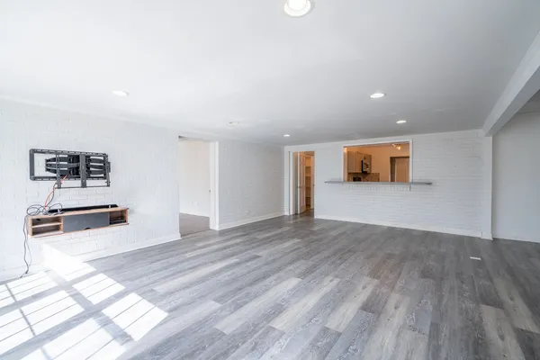 a view of empty room with wooden floor