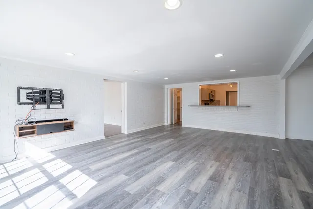 a view of empty room with wooden floor