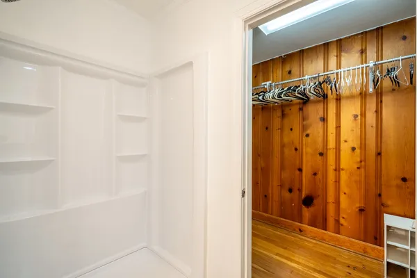 a view of walk in closet with clothes