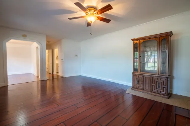 a view of an empty room with window and wooden floor