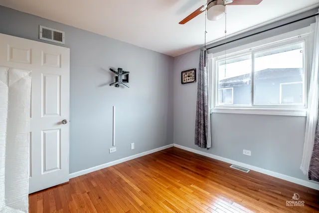 a view of a bedroom with wooden floor and windows