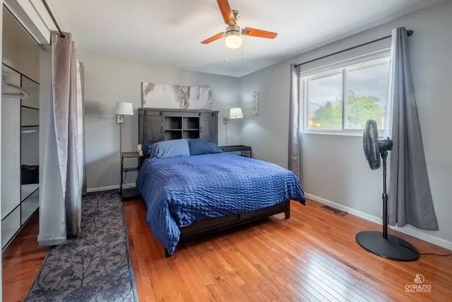 a bedroom with a bed and a wooden floor