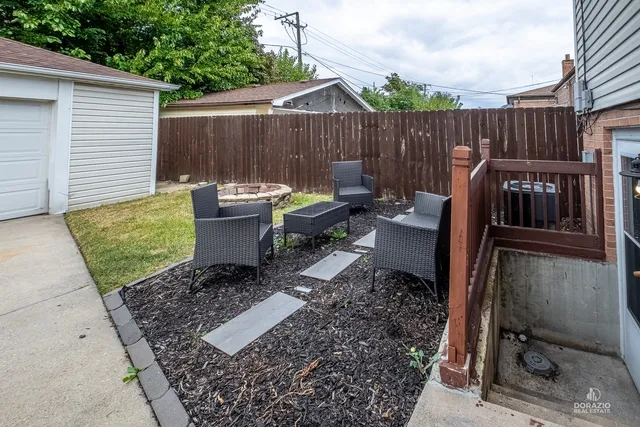 a view of a backyard with chairs and a fire pit