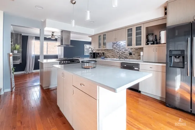 a kitchen with a center island wooden floor and stainless steel appliances