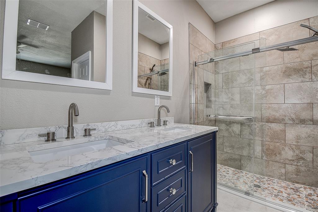 16519 US Highway 41 Spring Hill, FL 34610 - Photo 19 of 37 a bathroom with a granite countertop sink a mirror and shower