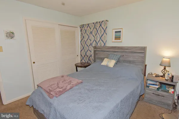 a bedroom with a bed and a lamp on the dresser