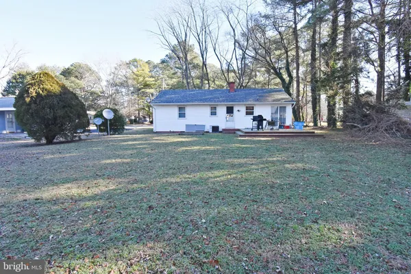 a view of a house with a yard and large trees