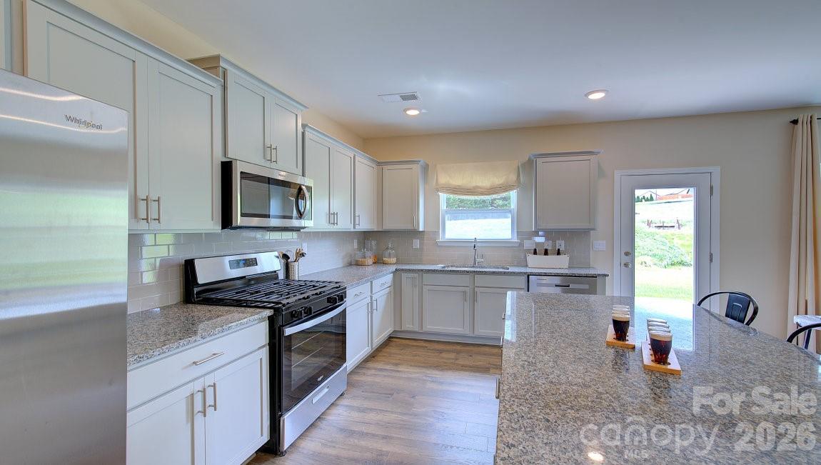 85 Salers Road Fletcher, NC 28732 - Photo 8 of 46 a kitchen with stainless steel appliances granite countertop a stove top oven a sink a counter space and cabinets