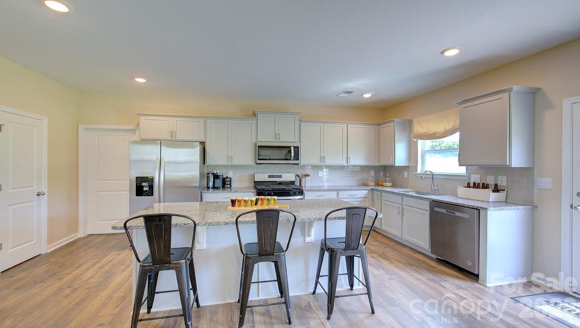 85 Salers Road Fletcher, NC 28732 - Photo 9 of 46 a kitchen with stainless steel appliances a dining table chairs refrigerator and microwave