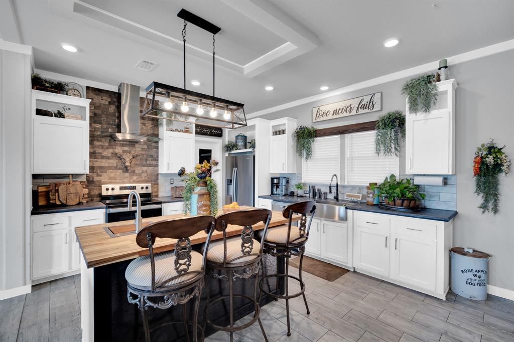 129 Old Blooming Grove Road Italy, TX 76651 - Photo 5 of 22 a kitchen with stainless steel appliances kitchen island granite countertop a dining table chairs and white cabinets