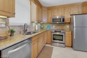 5600 Bonita Beach Road Southwest, Unit 503 Bonita Springs, FL 34134 - Photo 5 of 5 a kitchen with granite countertop a sink stove and refrigerator