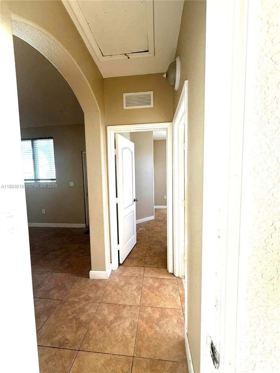 1656 Southeast 29th Court, Unit 207 Homestead, FL 33035 - Photo 14 of 31 a view of a hallway with wooden shelves and painted walls