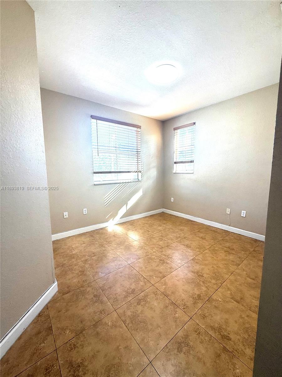 1656 Southeast 29th Court, Unit 207 Homestead, FL 33035 - Photo 18 of 31 an empty room with a empty space and windows