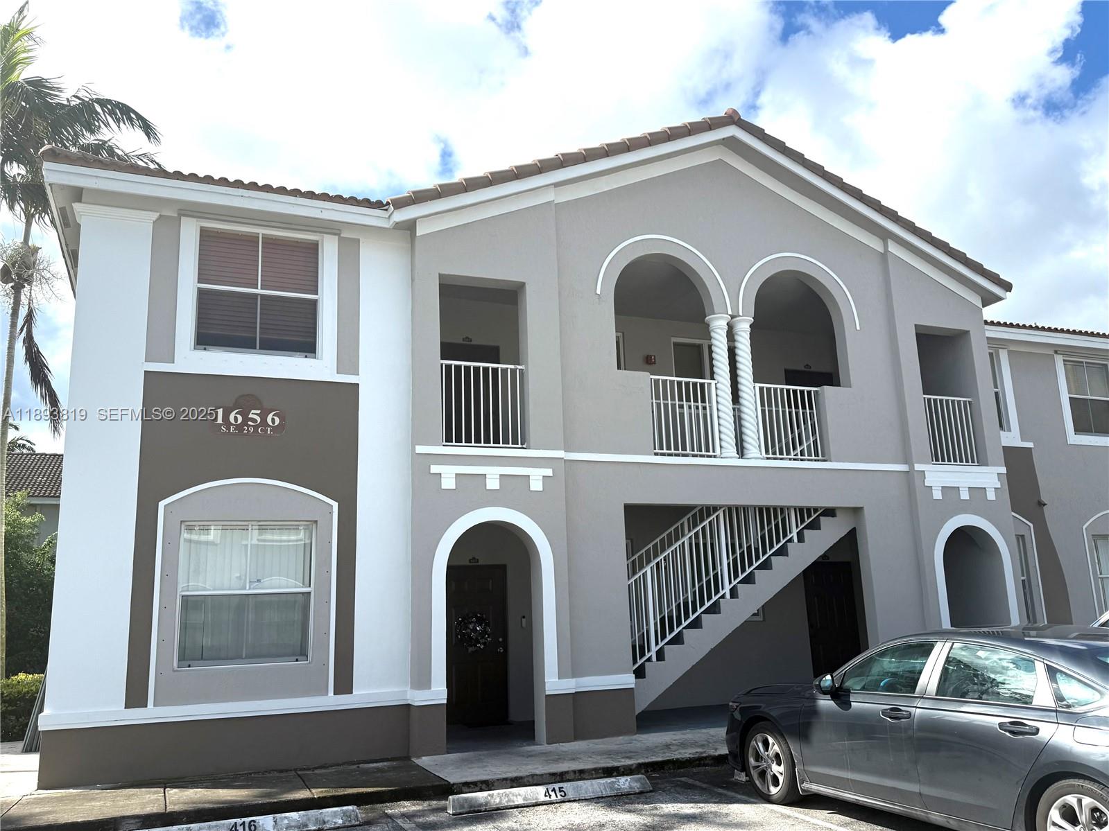 1656 Southeast 29th Court, Unit 207 Homestead, FL 33035 - Photo 2 of 31 a front view of a house with windows