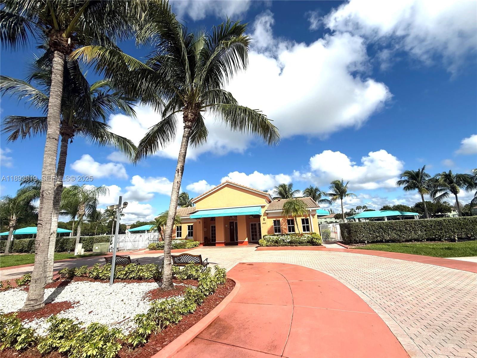 1656 Southeast 29th Court, Unit 207 Homestead, FL 33035 - Photo 27 of 31 a front view of a house with a fountain and a fire pit