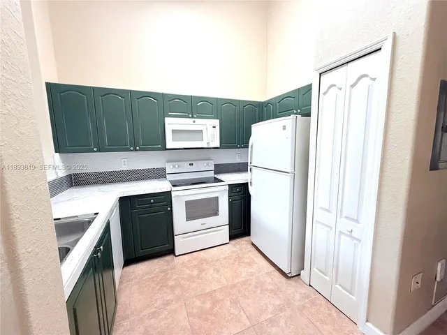 a kitchen with a refrigerator sink stove and cabinets