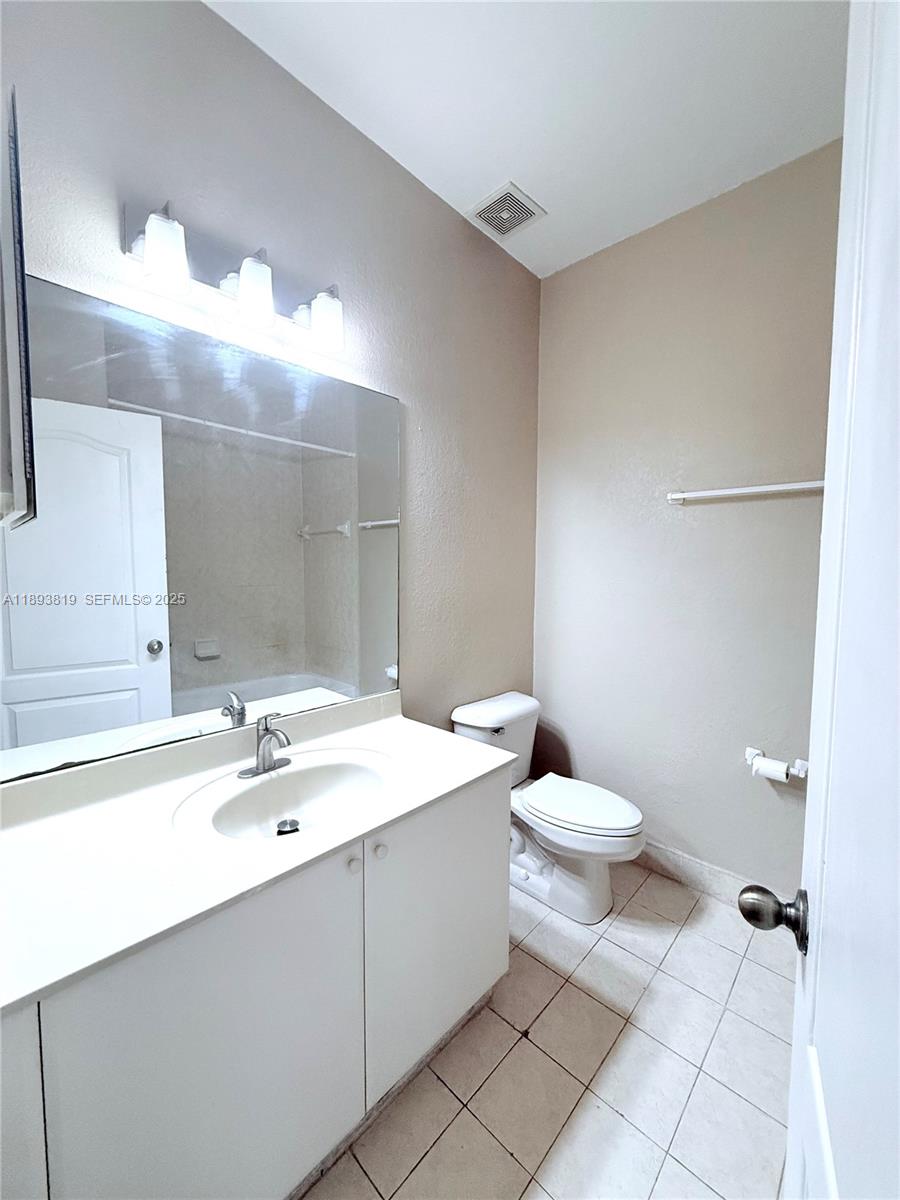 1656 Southeast 29th Court, Unit 207 Homestead, FL 33035 - Photo 7 of 31 a bathroom with a sink a toilet and mirror