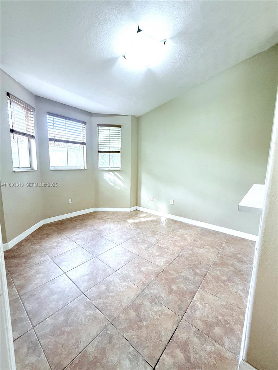 1656 Southeast 29th Court, Unit 207 Homestead, FL 33035 - Photo 10 of 31 an empty room with windows and entrance