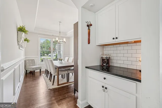 a kitchen with stainless steel appliances kitchen island granite countertop a sink a stove a dining table and chairs