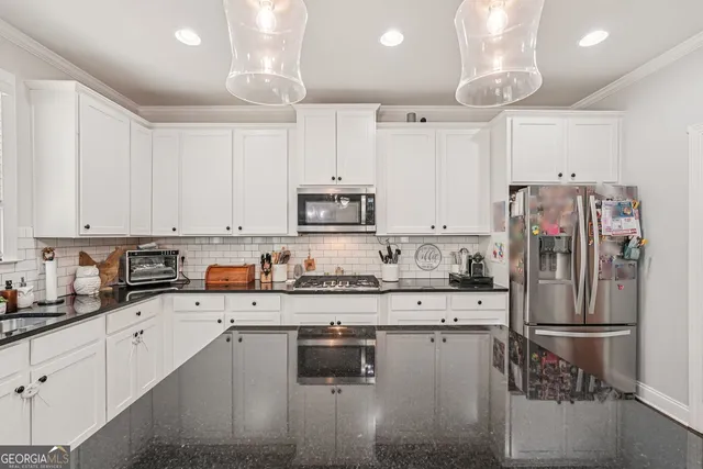 a kitchen with stainless steel appliances granite countertop a refrigerator sink and cabinets