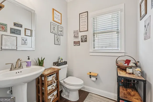 a bathroom with a sink toilet and a window