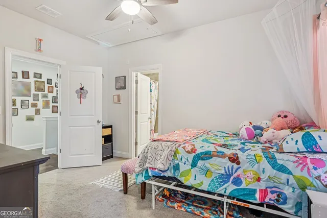 a bedroom with baby bed toys and paintings on the wall