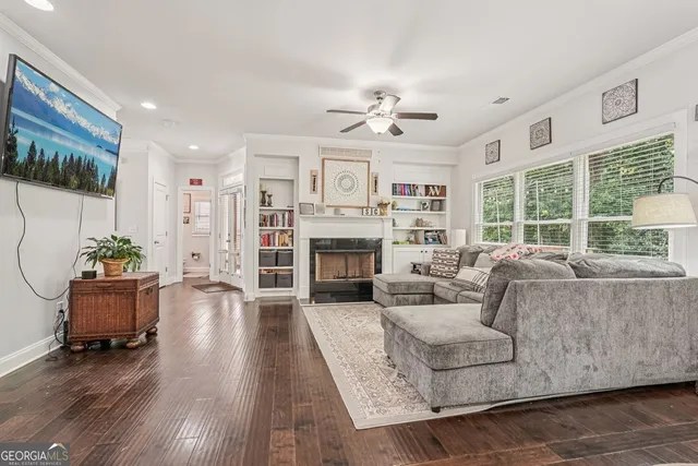 a living room with furniture fireplace and a large window