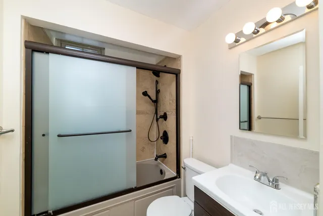 a bathroom with a toilet a sink and a mirror