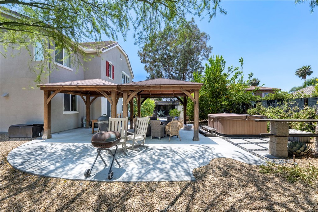 3819 St Austell Way Perris, CA 92571 - Photo 52 of 64 a view of a patio with table and chairs potted plants and a large tree