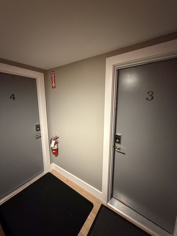 944 East Street, Unit 3 Walpole, MA 02081 - Photo 4 of 23 an empty room with wooden floor and entrance