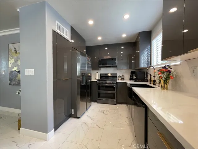 a kitchen with stainless steel appliances granite countertop a refrigerator and a sink