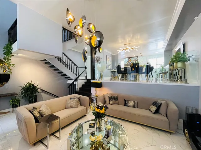 a living room with furniture stairs and a chandelier