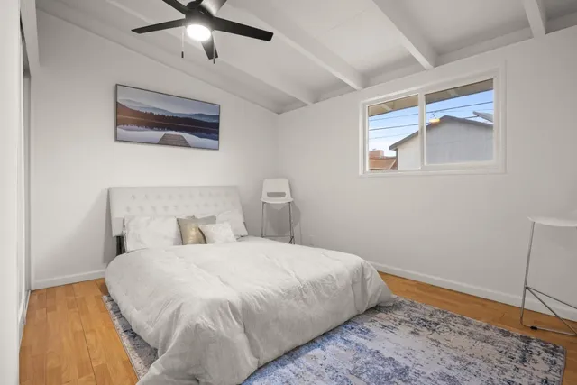 a bedroom with a bed and wooden floor
